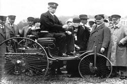 Carl Benz no seu primeiro veículo  motorizado e patenteado Modelo I em   1886, tirada em Munique no ano de 1925.